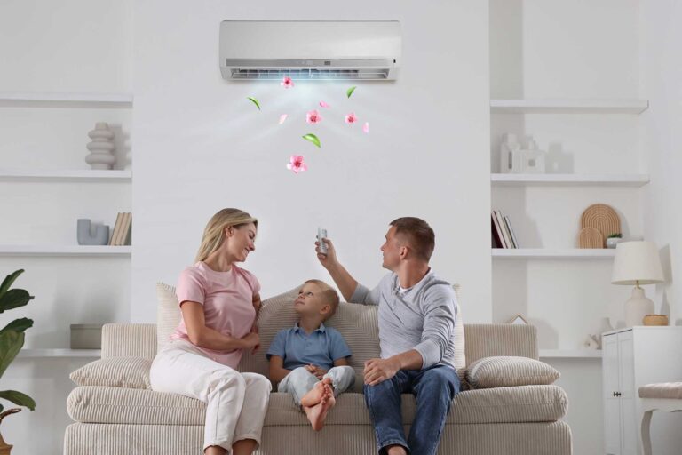 Famiglia davanti al condizionatore, come ridurre i consumi elettrici in estate: consigli per risparmiare sulla bolletta in estate. Elettricista BadoSante